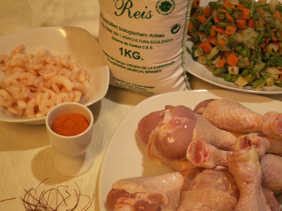 Zutaten für Paella Valenciana mit Reis, Garnelen, Gemüse und Hähnchen